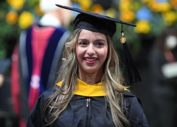 Estudiante de SNHU el día de su graduación sonriendo